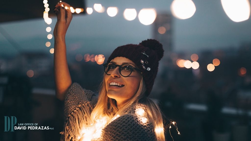 Woman hanging Christmas lights - Your First Holidays After Divorce